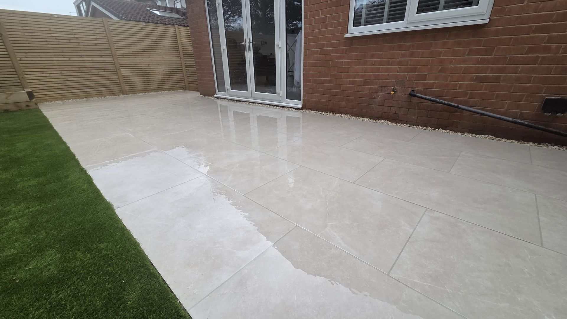Amalfi Beige porcelain patio with artificial grass and contemporary fencing in Chapel Allerton
