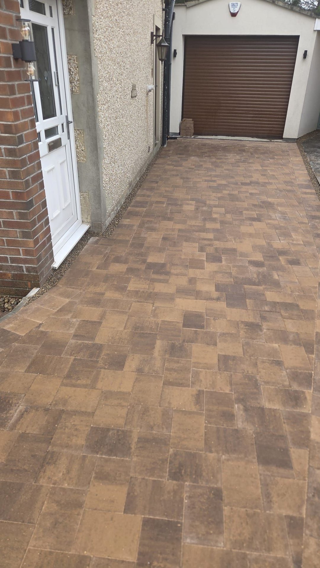 Completed block paved patio and garden path around a stone home